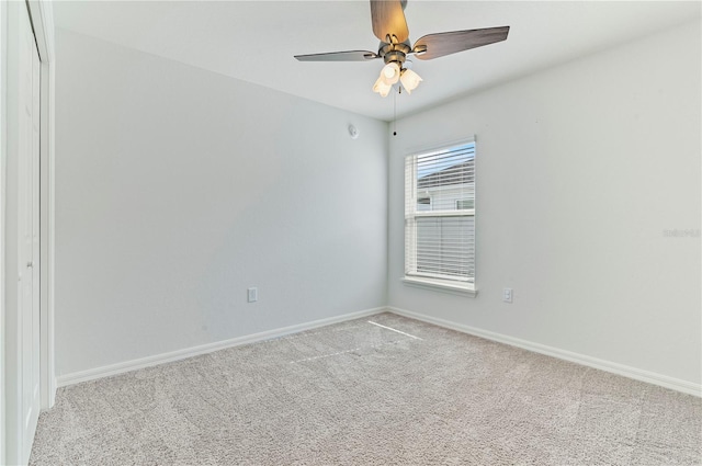 carpeted spare room with ceiling fan