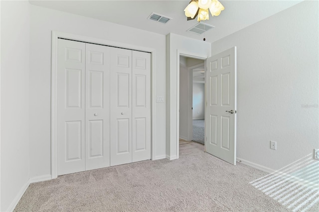 unfurnished bedroom with light carpet and a closet