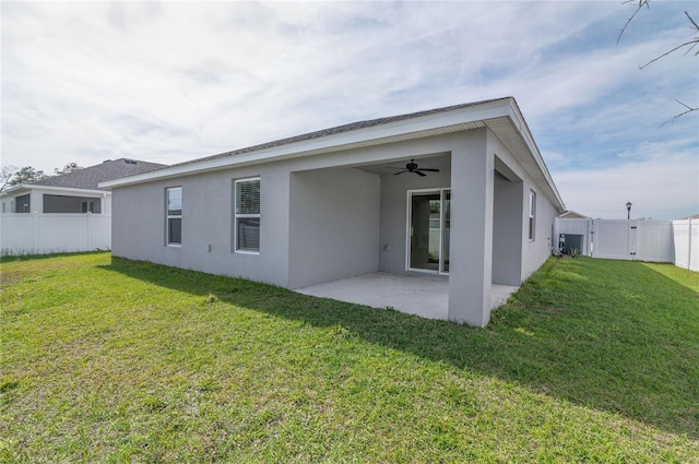 back of property featuring a yard, a patio area, and ceiling fan