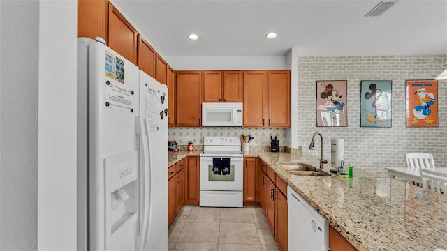 kitchen featuring white appliances, light stone counters, visible vents, light tile patterned flooring, and a sink