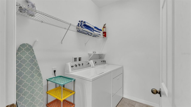 laundry area with washer and clothes dryer and light tile patterned flooring