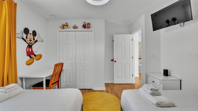 bedroom featuring baseboards, a closet, and light wood-type flooring