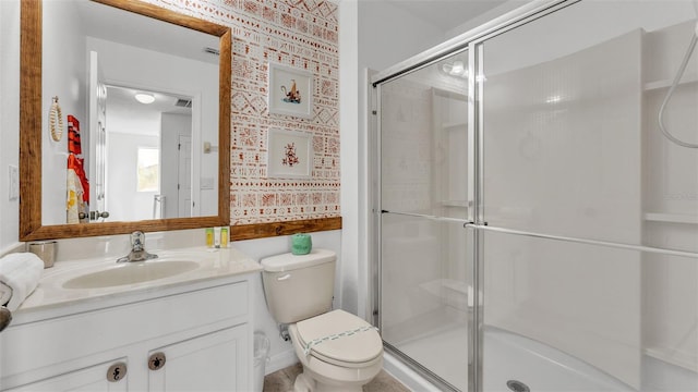 full bathroom featuring a shower stall, vanity, and toilet