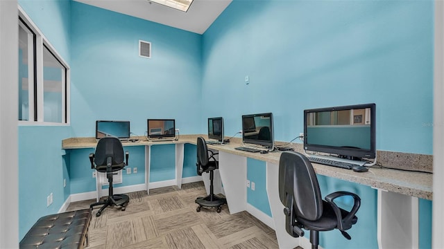 home office featuring visible vents, built in desk, and baseboards