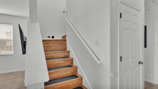 stairs with tile patterned floors and baseboards