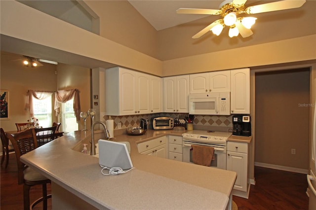 kitchen with white appliances, sink, kitchen peninsula, dark hardwood / wood-style floors, and white cabinetry