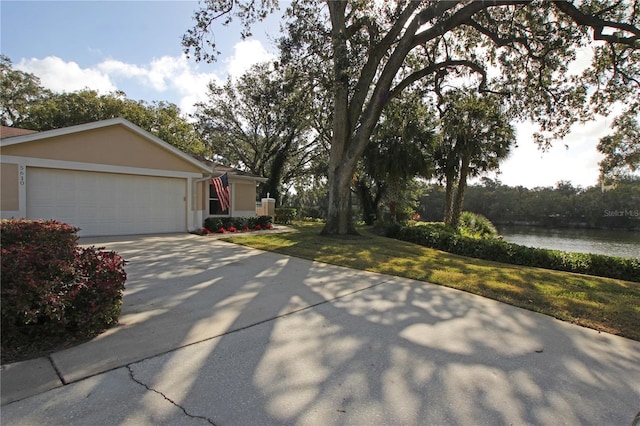 view of front of home featuring a garage, a water view, and a front yard