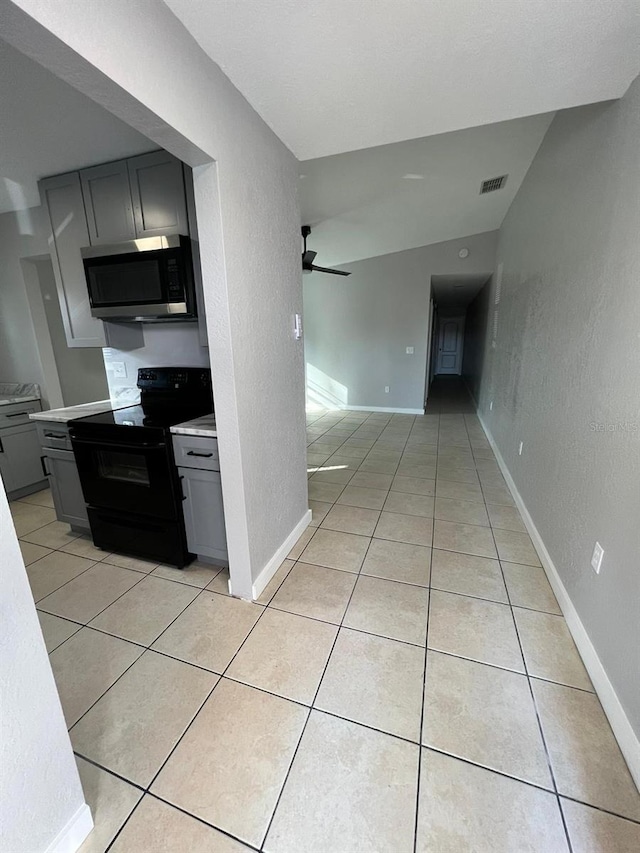 kitchen featuring gray cabinetry, ceiling fan, black electric range oven, and light tile patterned floors