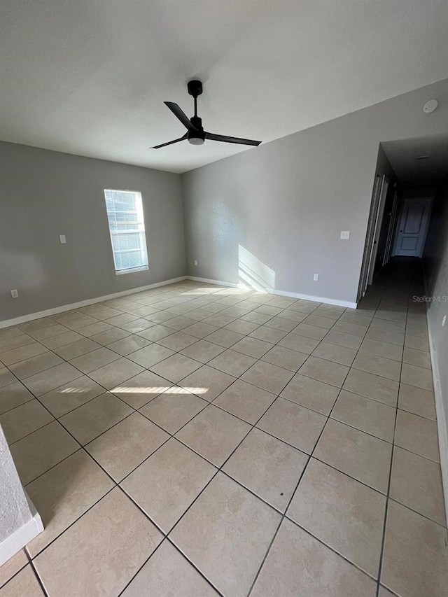 tiled spare room with ceiling fan