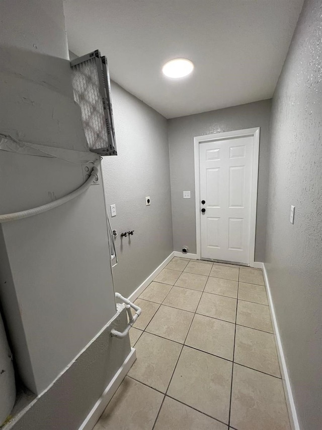 laundry area with electric dryer hookup, hookup for a washing machine, and light tile patterned flooring