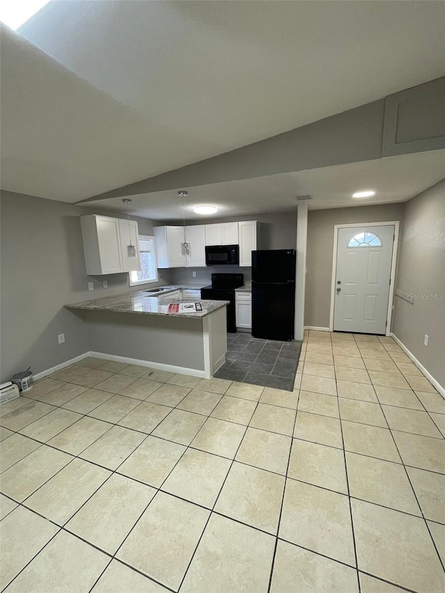 kitchen with kitchen peninsula, light tile patterned flooring, white cabinetry, and black appliances