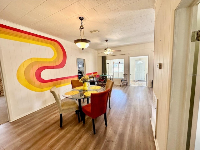 dining area featuring baseboards, a ceiling fan, and wood finished floors