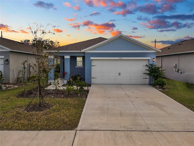 ranch-style home with a garage and a lawn