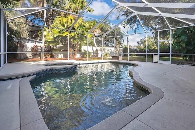 view of swimming pool with glass enclosure and a patio area