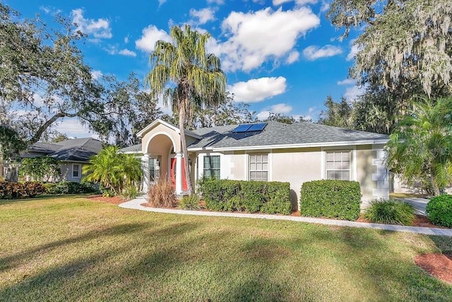 view of front of home featuring a front yard and solar panels