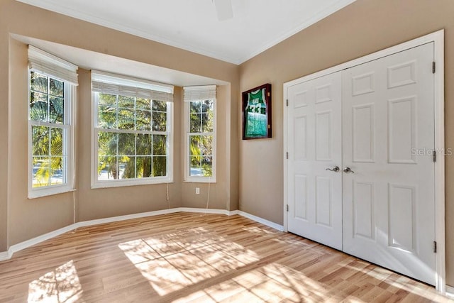 interior space featuring ceiling fan, light hardwood / wood-style floors, and ornamental molding