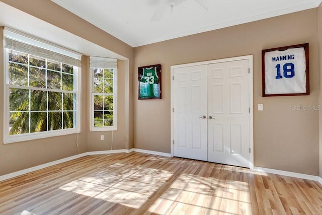 entrance foyer featuring light wood-type flooring, ceiling fan, and crown molding