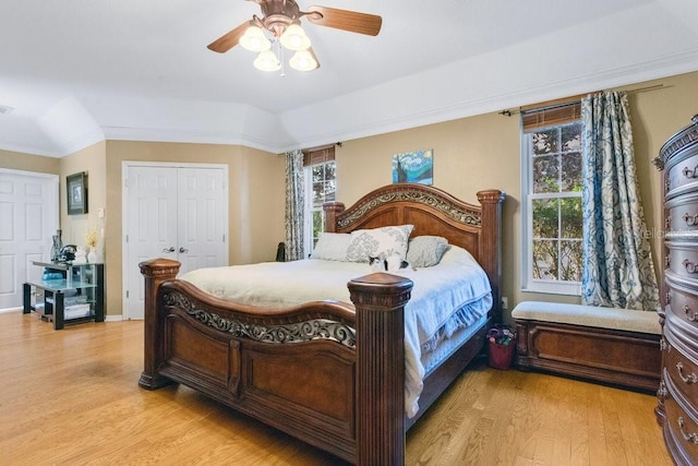 bedroom with ceiling fan, a closet, ornamental molding, and light wood-type flooring