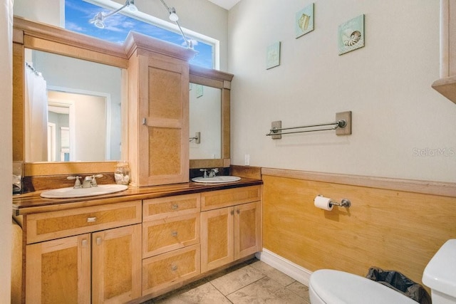 bathroom with tile patterned flooring, vanity, and toilet