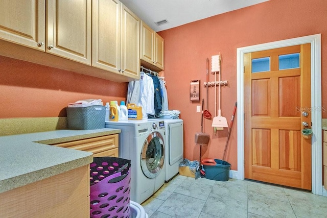 washroom with cabinets, light tile patterned floors, and washer and dryer