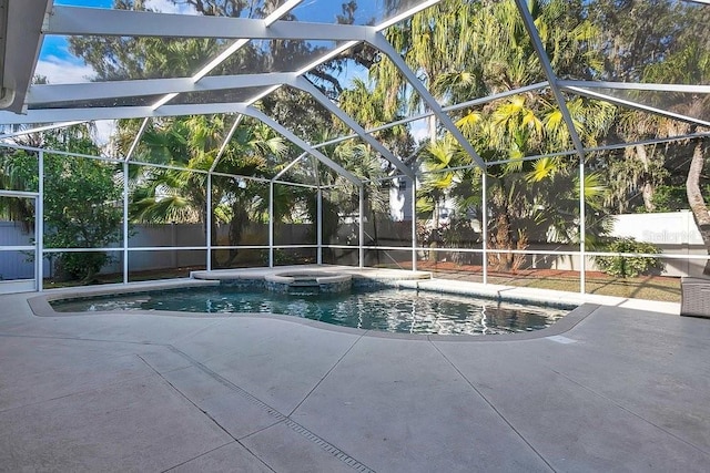 view of swimming pool featuring glass enclosure, an in ground hot tub, and a patio