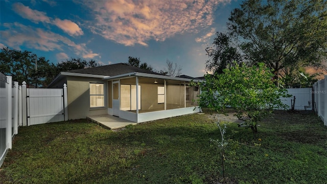 property exterior at dusk with a yard