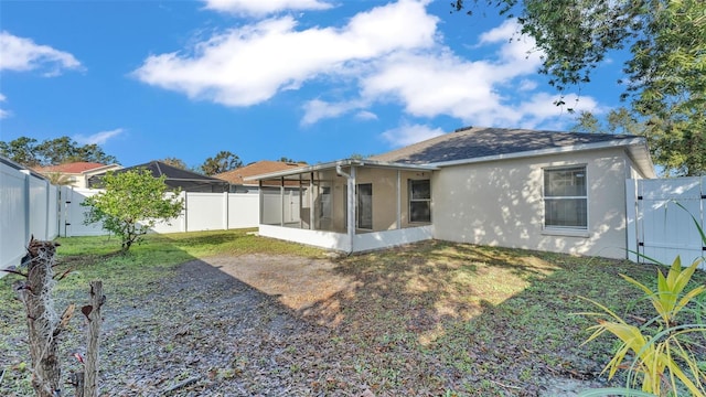 rear view of property featuring a sunroom and a yard