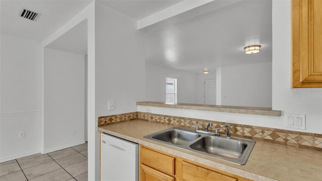 kitchen with light tile patterned floors, white dishwasher, light brown cabinetry, and sink