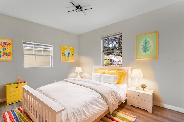 bedroom featuring wood finished floors and baseboards