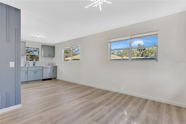 interior space with light wood-type flooring, baseboards, and stainless steel dishwasher