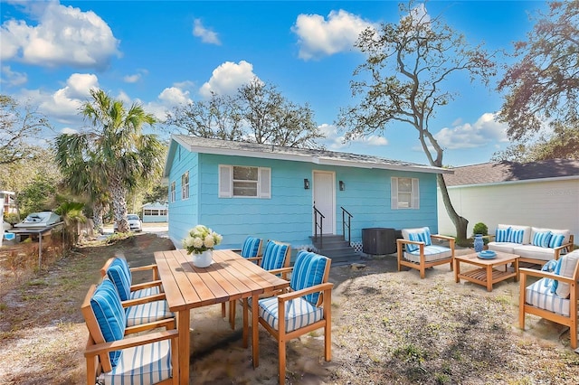 rear view of property featuring entry steps, a patio, outdoor dining space, and an outdoor living space