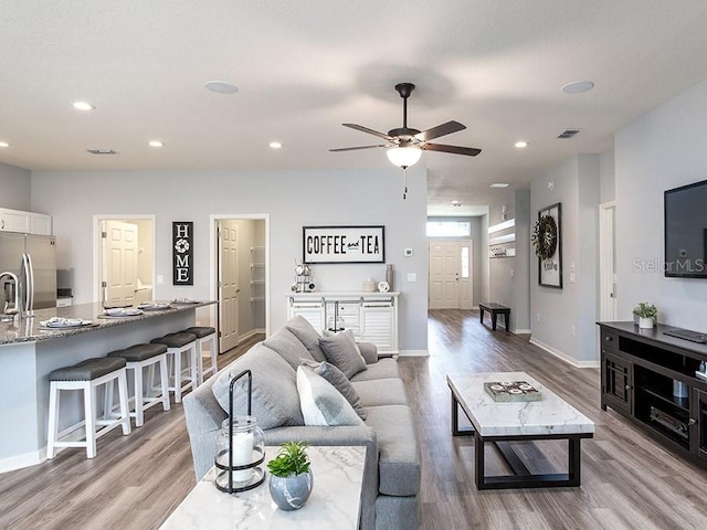 living room featuring light hardwood / wood-style flooring and ceiling fan