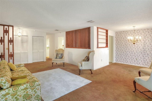 living room featuring carpet floors, a textured ceiling, and a notable chandelier