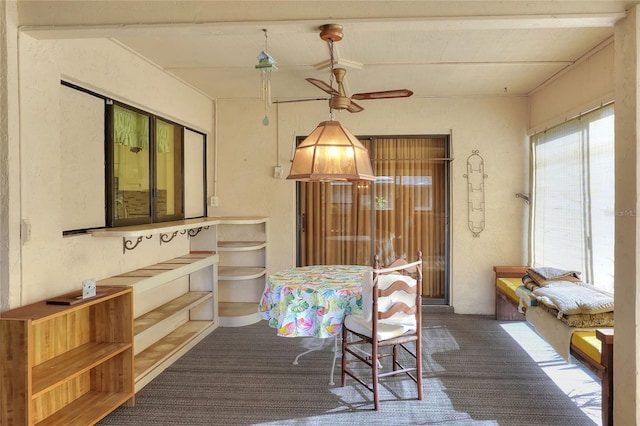 carpeted dining area with ceiling fan