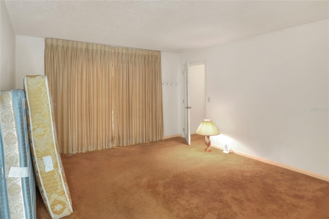 empty room with carpet and a textured ceiling