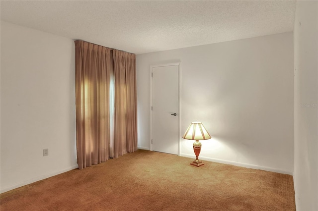 empty room with a textured ceiling and carpet floors