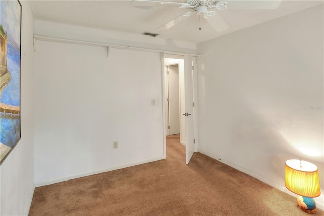 empty room with ceiling fan and light carpet