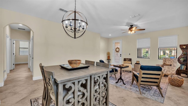 tiled dining area with ceiling fan with notable chandelier