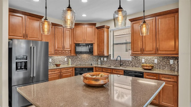 kitchen featuring decorative light fixtures, sink, a kitchen island, and black appliances