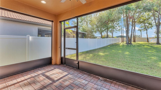 unfurnished sunroom featuring ceiling fan