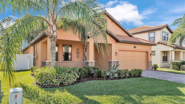 mediterranean / spanish-style home featuring a garage and a front yard