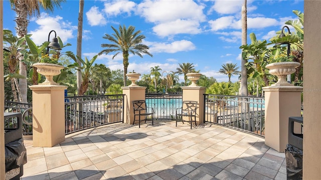 view of patio / terrace featuring a community pool and a water view