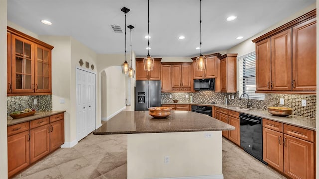 kitchen with sink, tasteful backsplash, a center island, hanging light fixtures, and black appliances