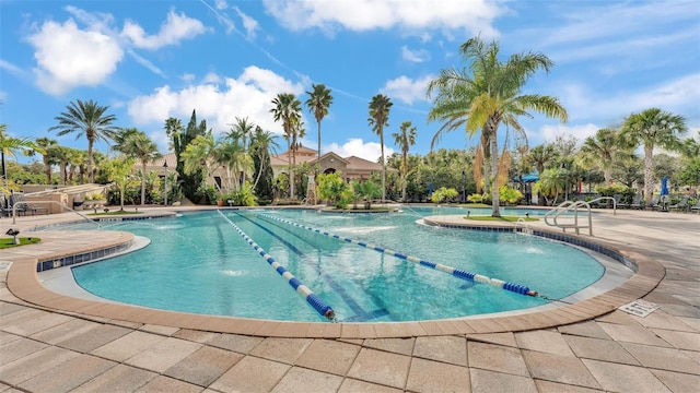 view of swimming pool with pool water feature and a patio