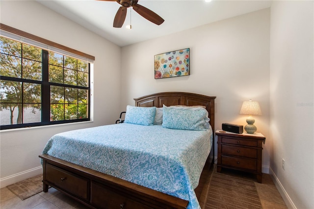 bedroom with dark tile patterned flooring and ceiling fan