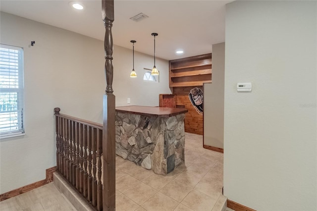 bar featuring light tile patterned floors and hanging light fixtures