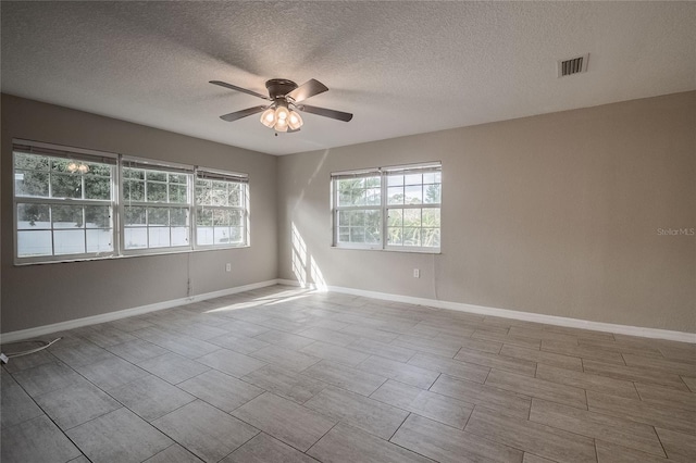 empty room featuring ceiling fan and a textured ceiling