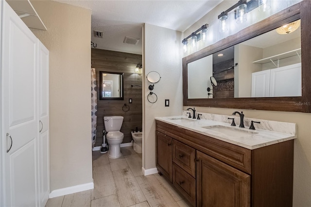 bathroom featuring a shower, wood walls, hardwood / wood-style floors, a bidet, and vanity