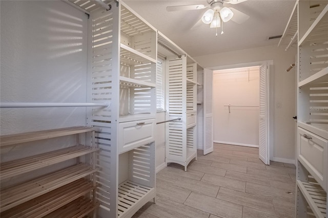 walk in closet with ceiling fan