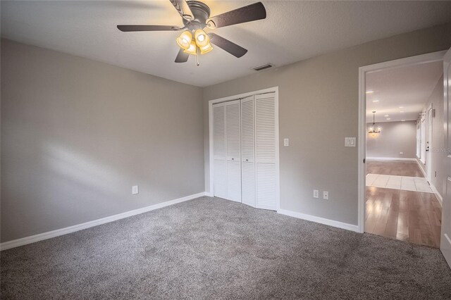 unfurnished bedroom featuring light carpet, a closet, and ceiling fan